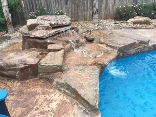 There is a waterfall in the middle of the pool.