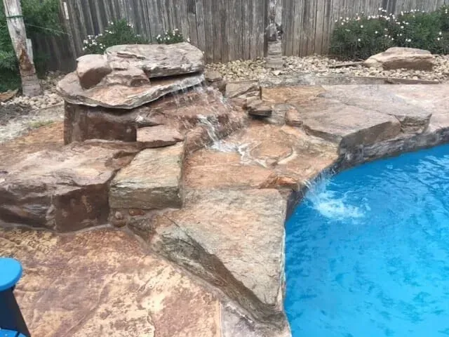 There is a waterfall in the middle of the pool.