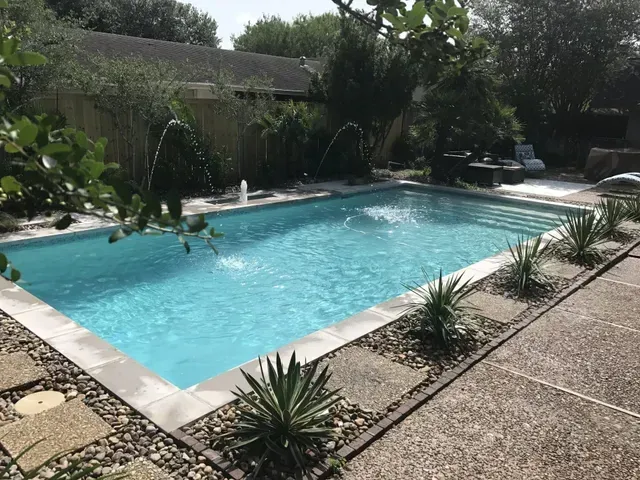 A large swimming pool in the backyard of a house