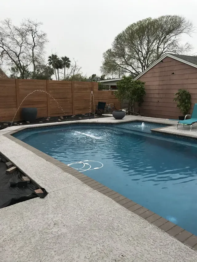 A large swimming pool with a fountain in the middle of it