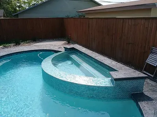 A large swimming pool with a wooden fence surrounding it.