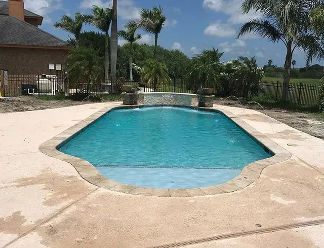 A large swimming pool with palm trees in the background