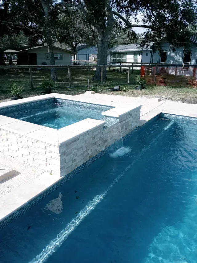 A large swimming pool with a waterfall in the middle