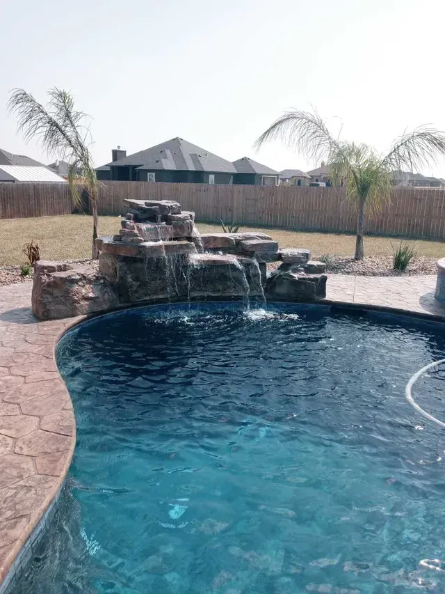 There is a waterfall in the middle of the pool.
