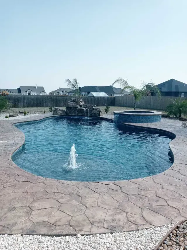 A large swimming pool with a fountain in the middle of it.