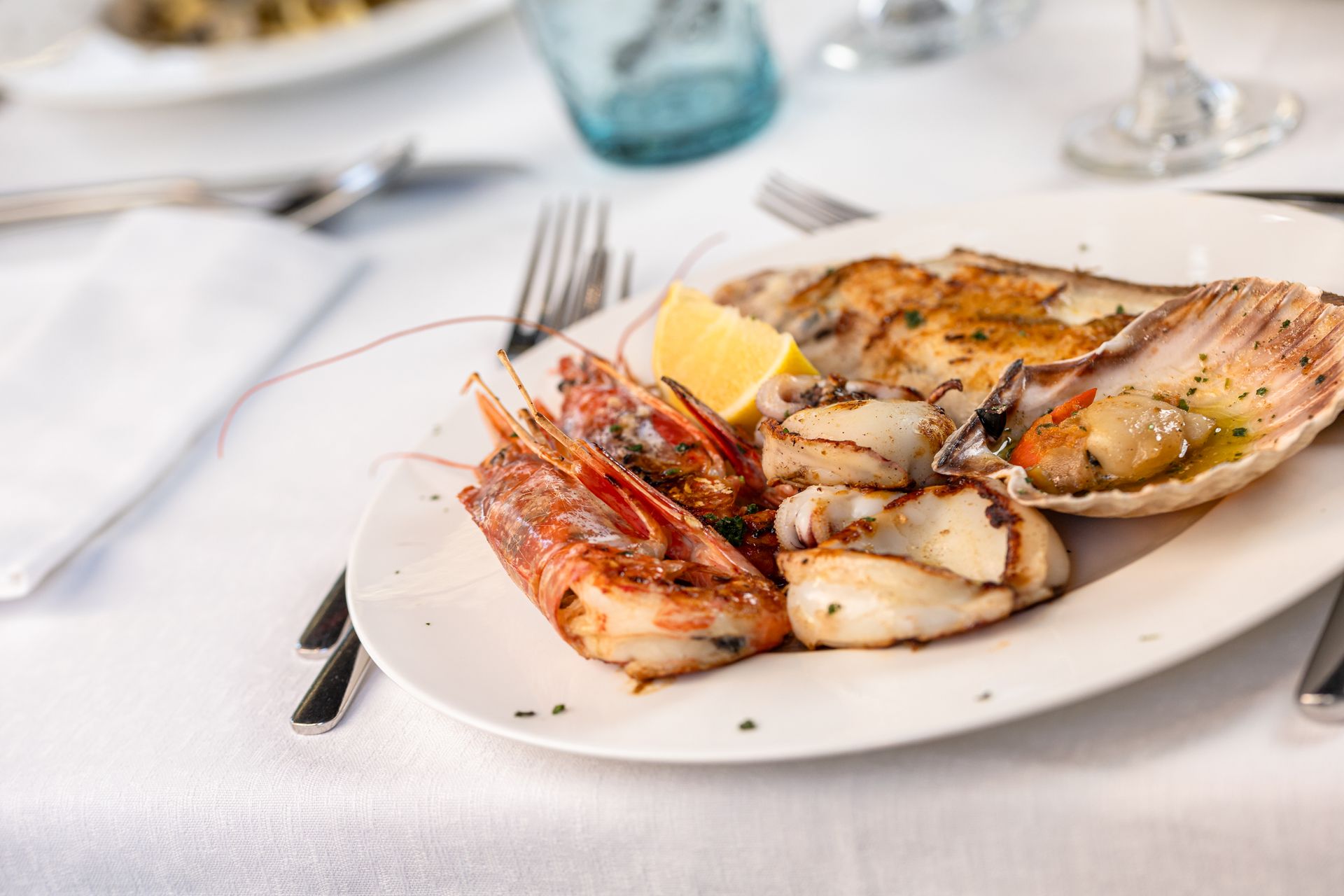 A white plate topped with shrimp and squid on a table.
