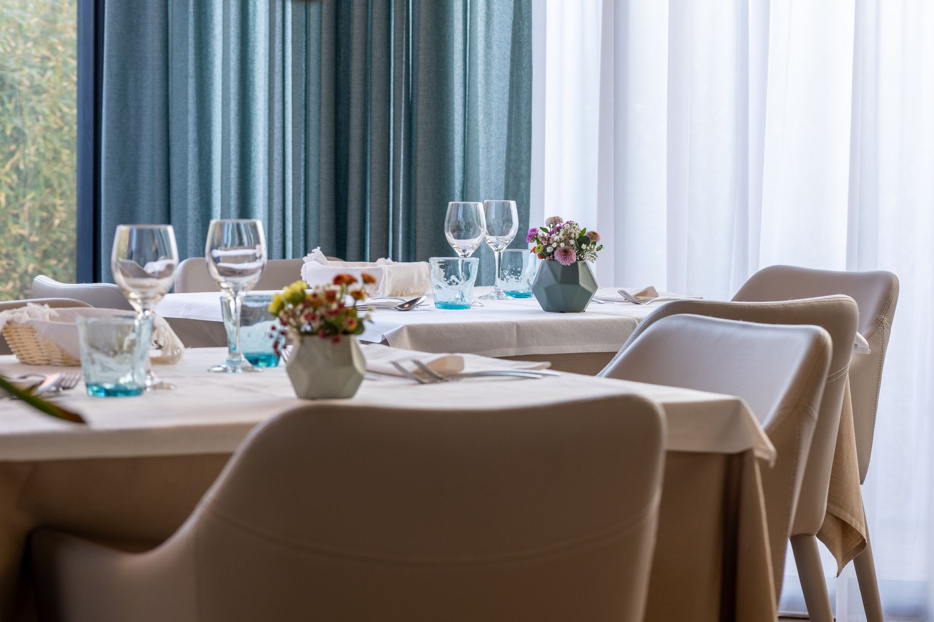 A restaurant with tables and chairs set for a meal.