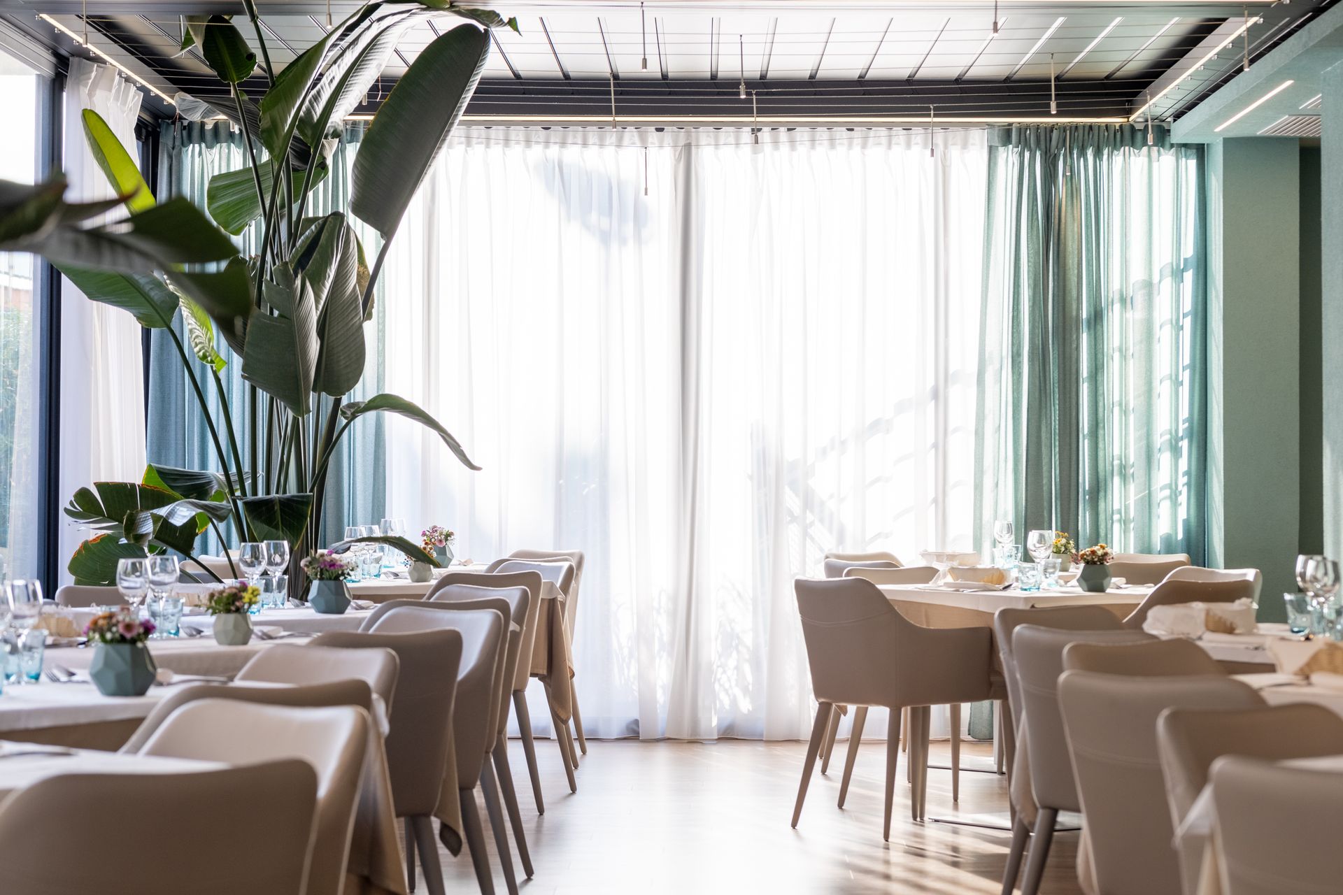 A restaurant with tables and chairs and a large window.