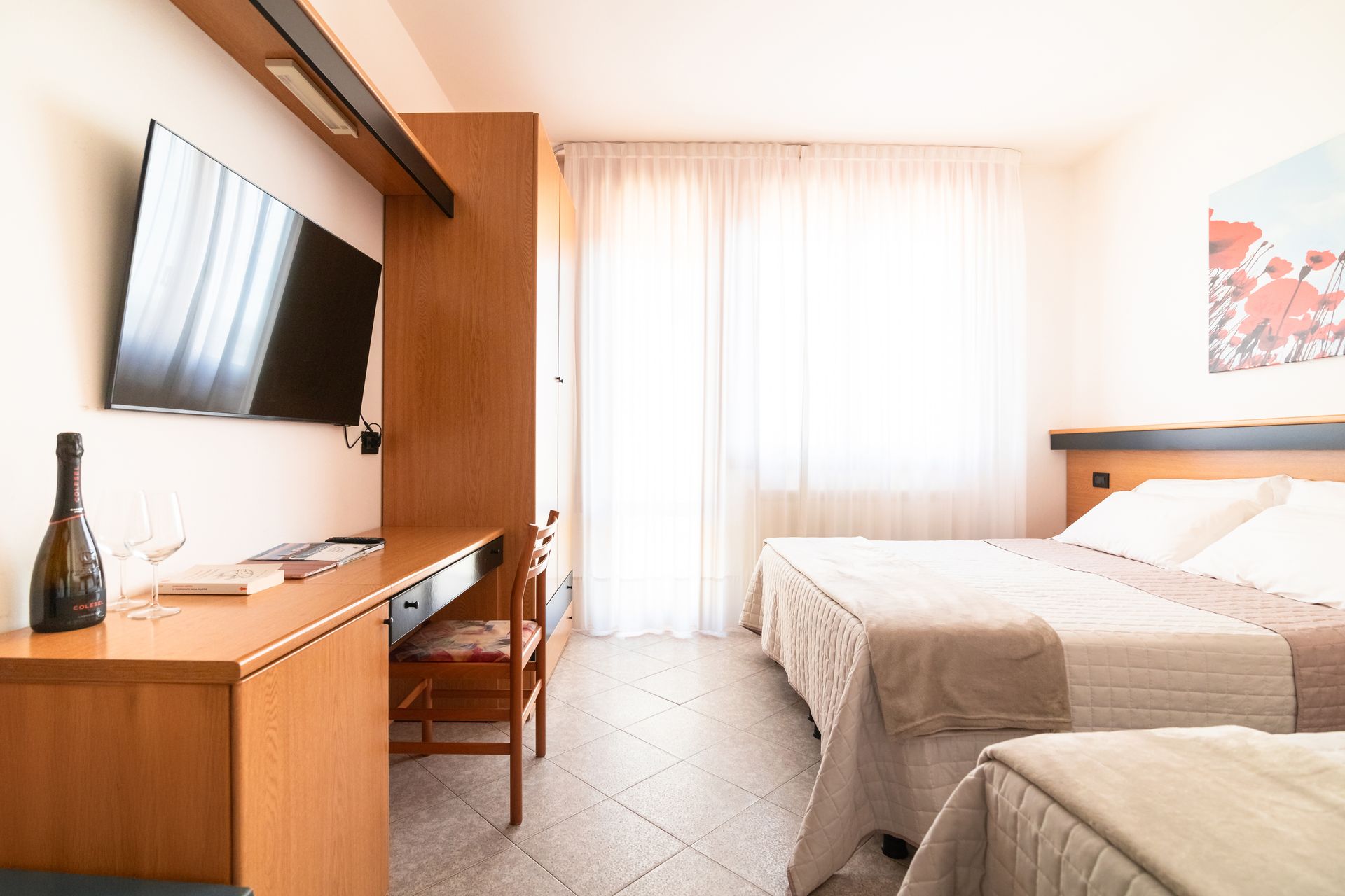 A hotel room with two beds and a flat screen tv