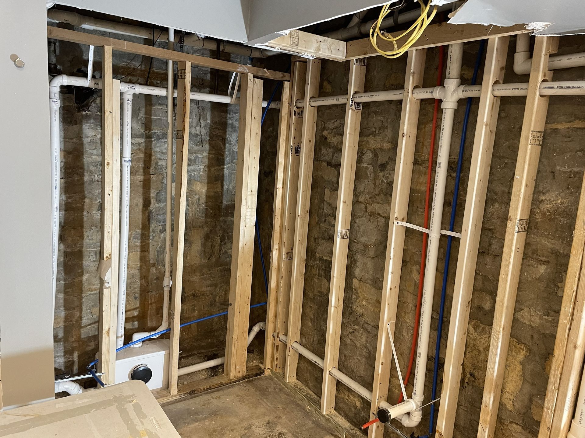 Exposed wall studs and plumbing in an unfinished interior renovation area