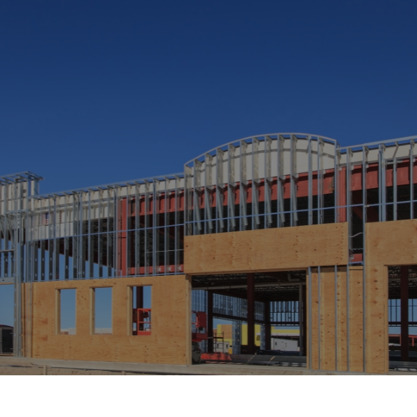 Modern building exterior with wood paneling and vertical metal slats under a clear blue sky