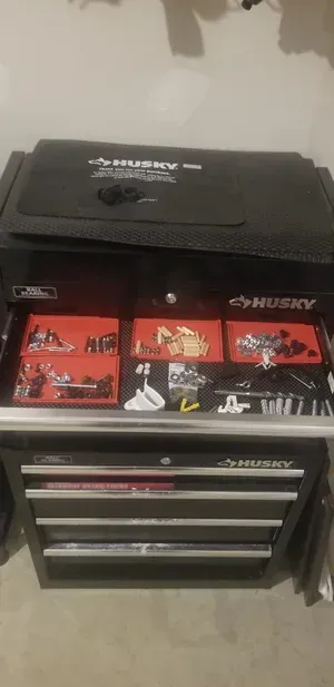 Black tool chest with red drawers and a black top box in a garage or workshop setting