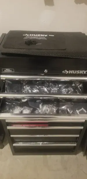 Black Husky tool chest with stacked drawers and a top compartment in a garage or workshop setting