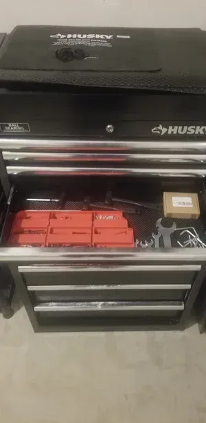 Black Husky toolbox drawer with orange battery packs and a white charger inside.