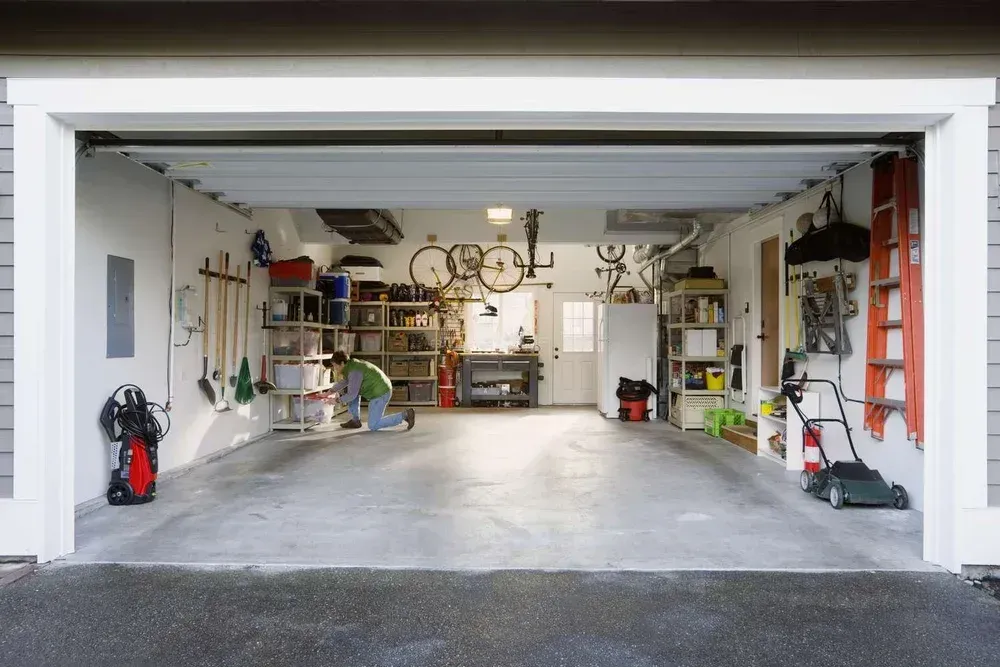 Open garage with shelves, tools, bikes, and storage along the walls