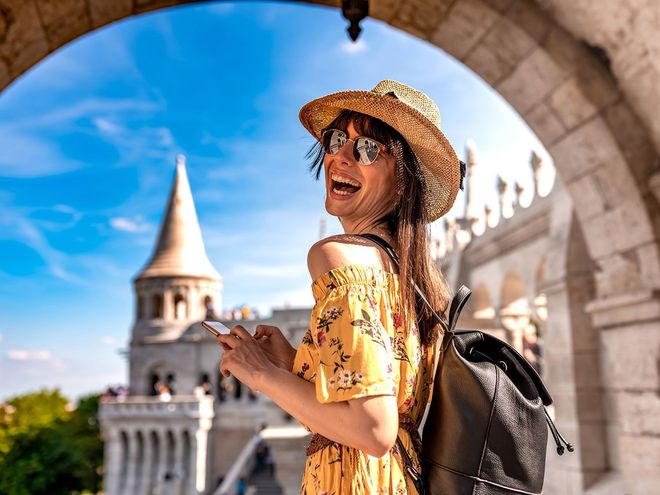 Smiling traveler with a castle tower in the background Smiling traveler with a castle tower in the background
