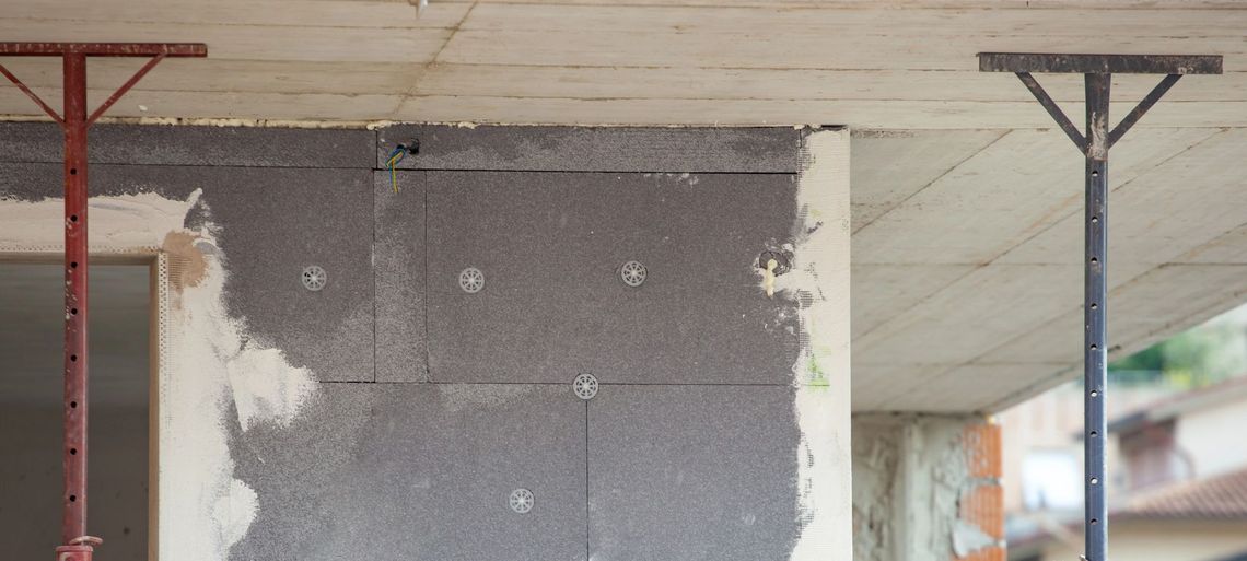 Cucina moderna con isola, mobili in legno, illuminazione sottopensile calda ed elettrodomestici in acciaio inossidabile.