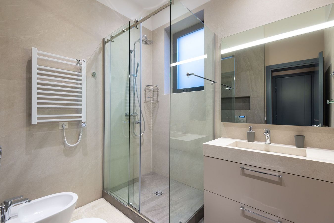 Cucina moderna con isola, mobili in legno, illuminazione sottopensile calda ed elettrodomestici in acciaio inossidabile.