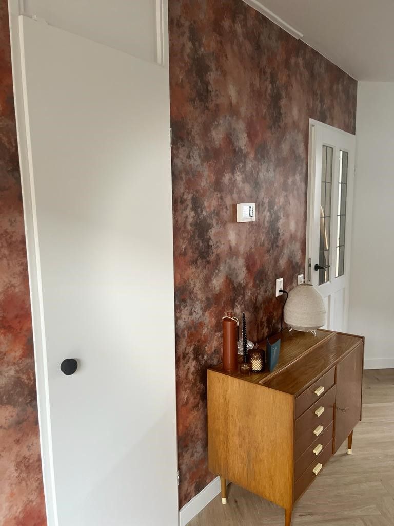 Een houten ladekast staat in een kamer naast een deur.