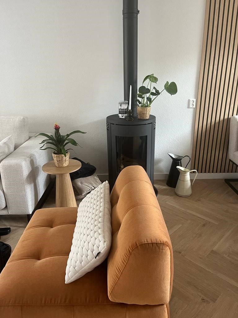 Een woonkamer met een bank en een open haard.