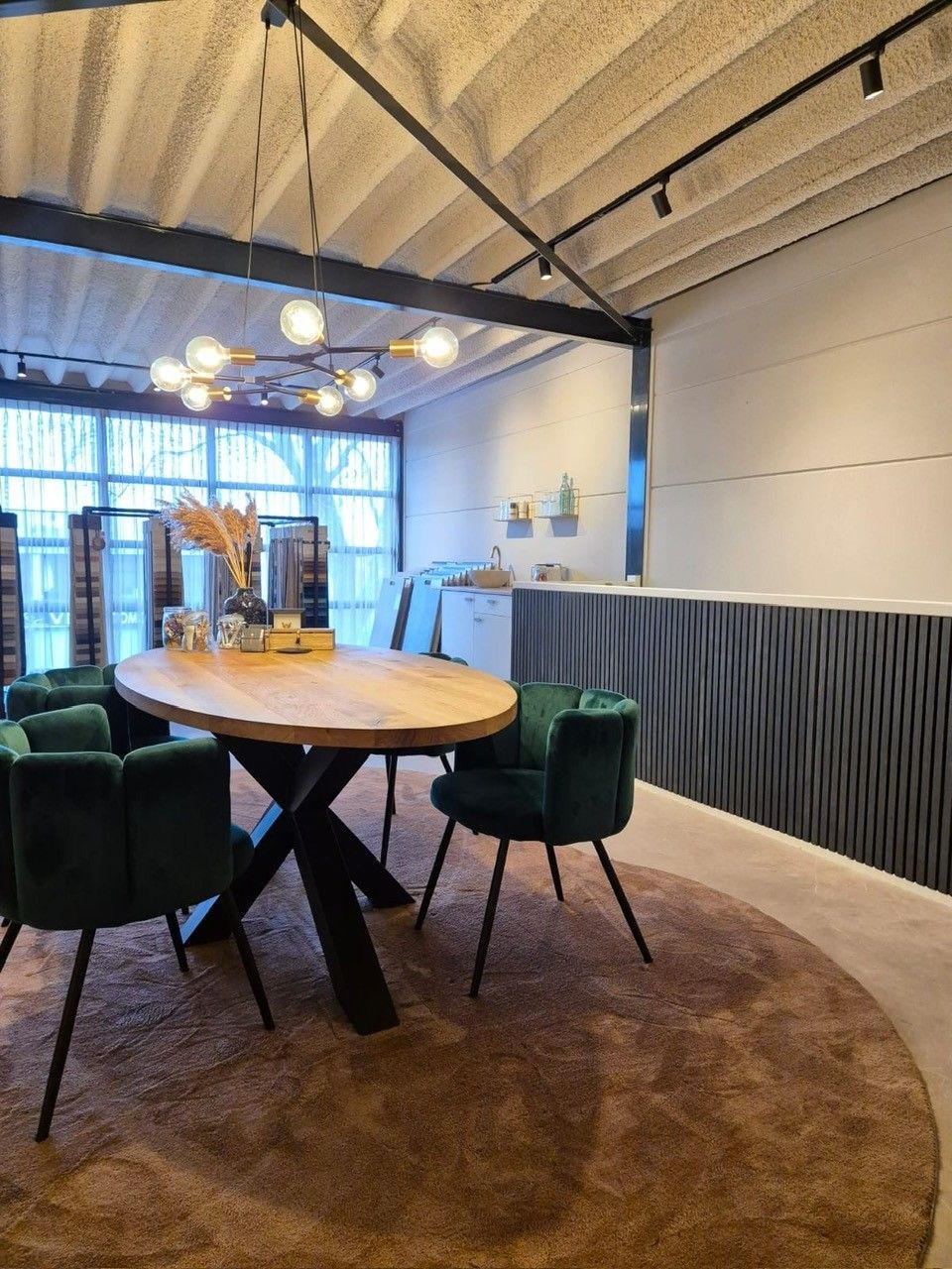 Een eetkamer met een houten tafel en groene stoelen