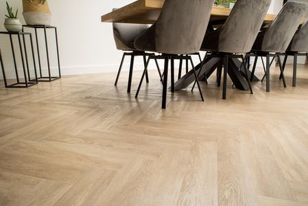 Een eetkamer met een tafel en stoelen op een houten vloer.