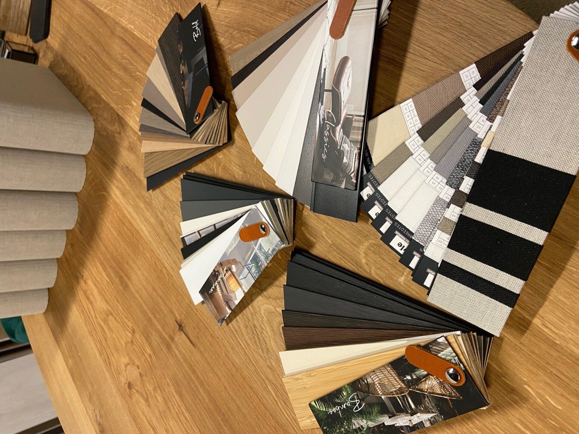 Op een houten tafel liggen een aantal stofstalen.