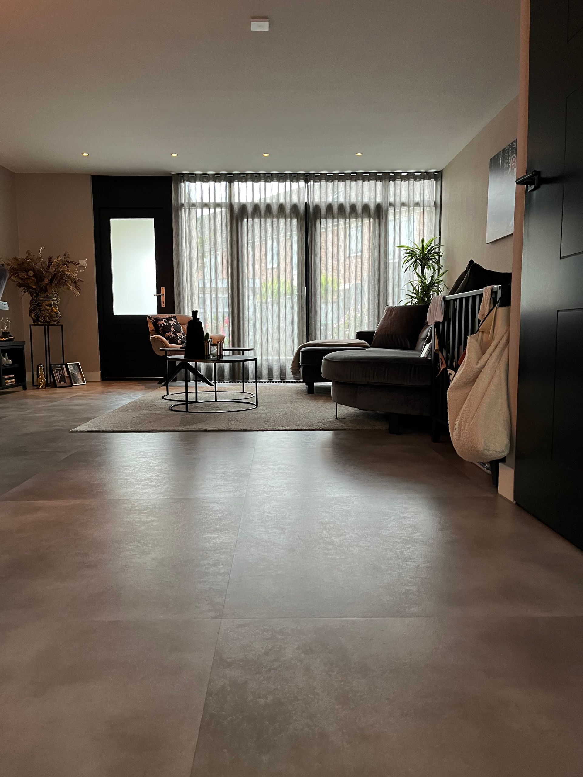 Een woonkamer met veel meubels en een groot raam
