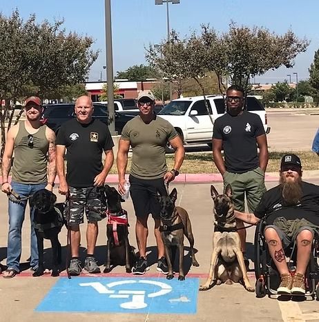 A group of men standing next to their dogs in a parking lot