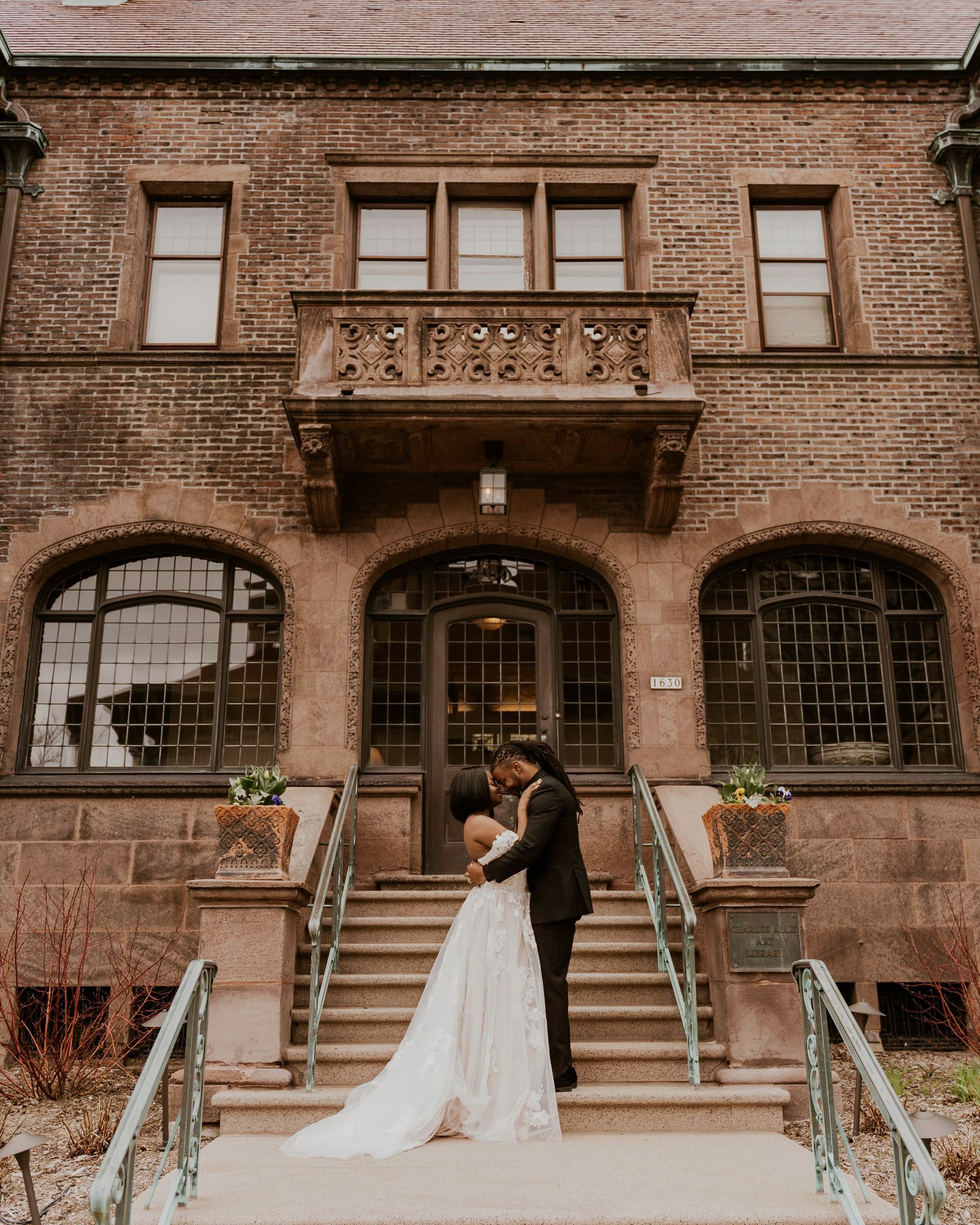 A bride and groom are posing for a picture in front of a tree.