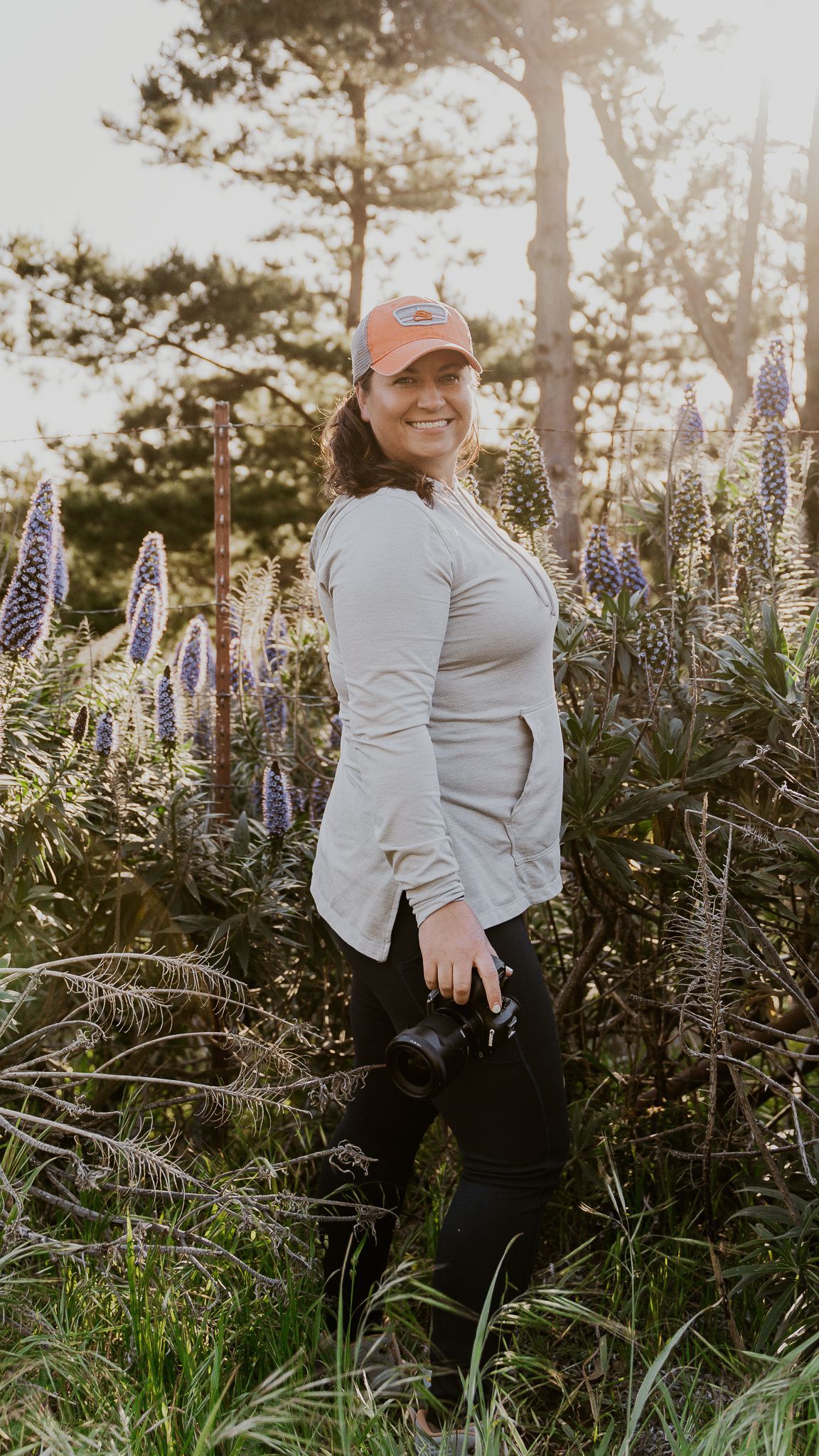 A woman is standing in a field of flowers.