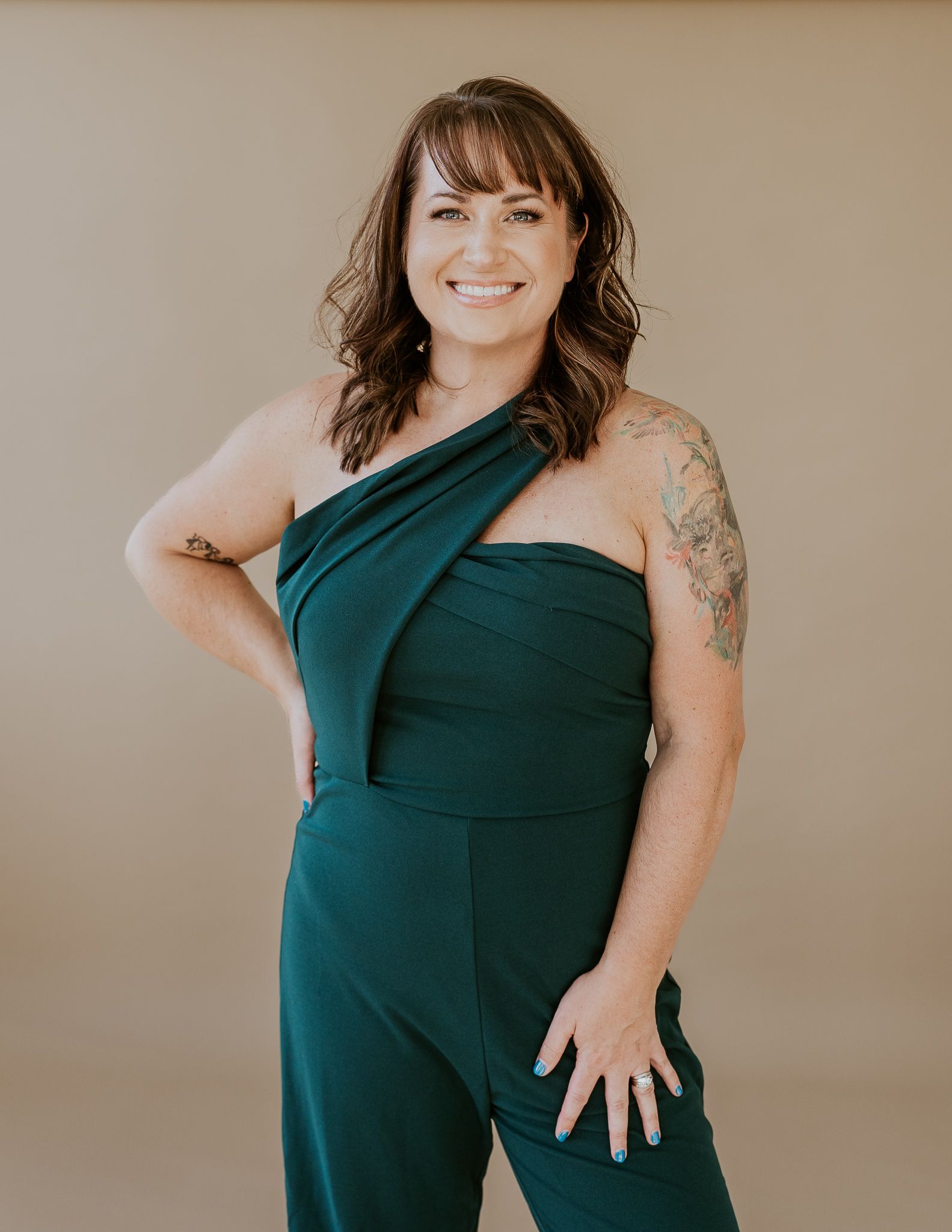A woman is standing in a studio smiling.