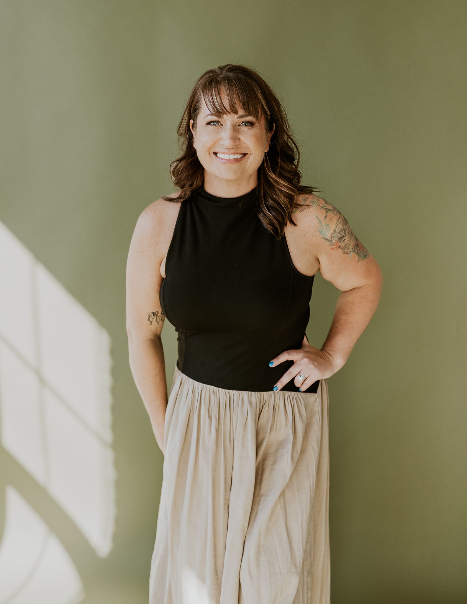 A woman is standing in a studio smiling.