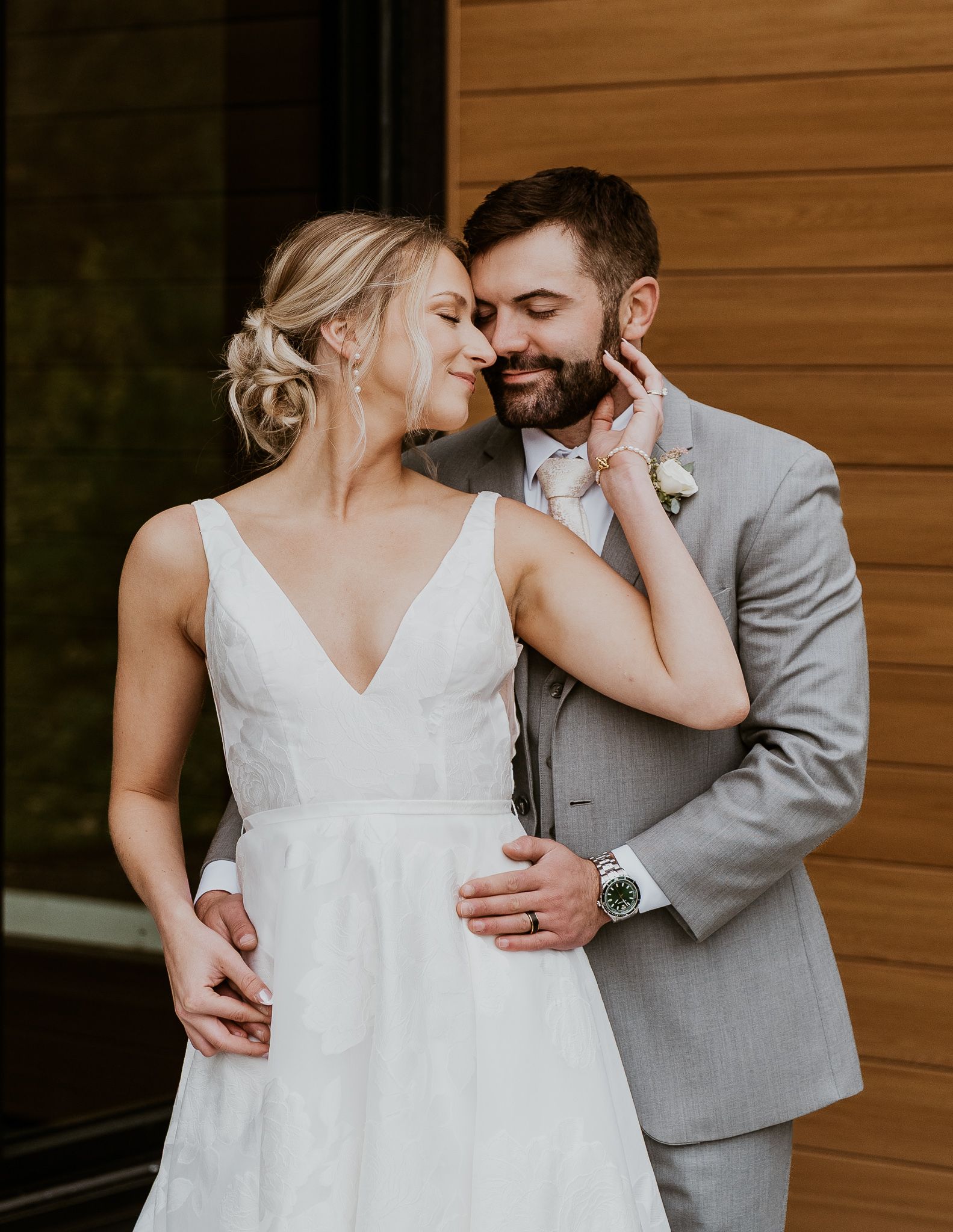 A bride and groom are posing for a picture in front of a tree.