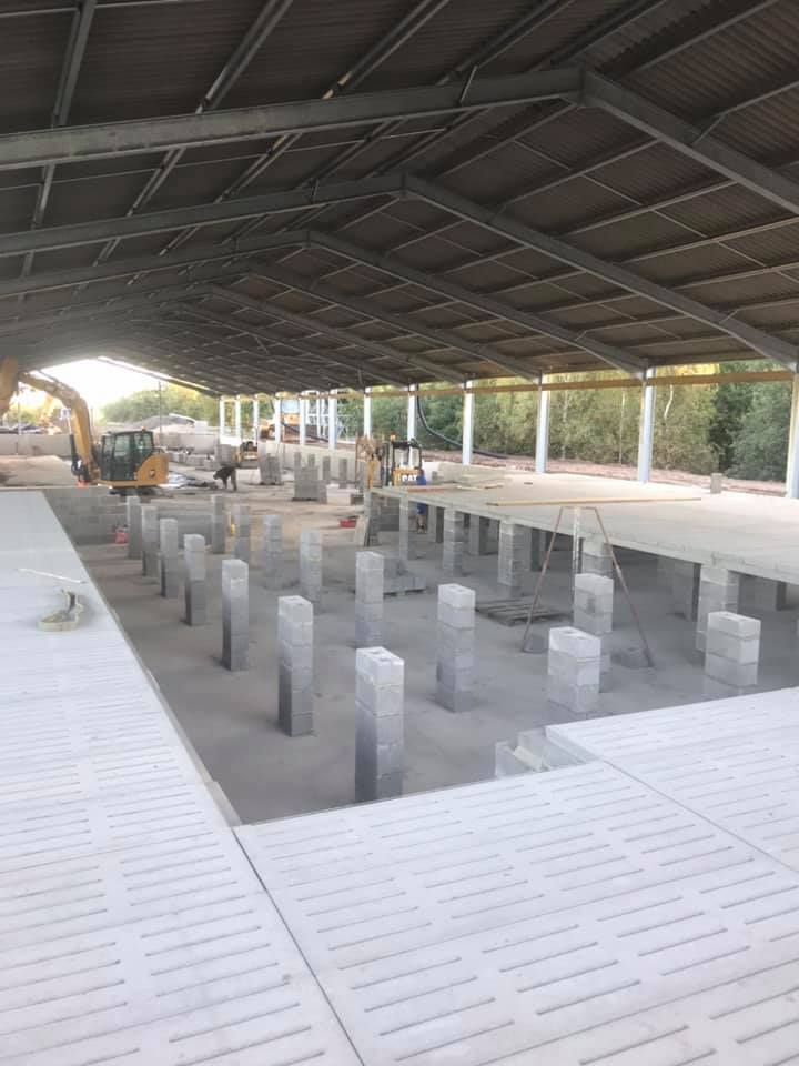 Large building under construction with a roof and a lot of pillars.