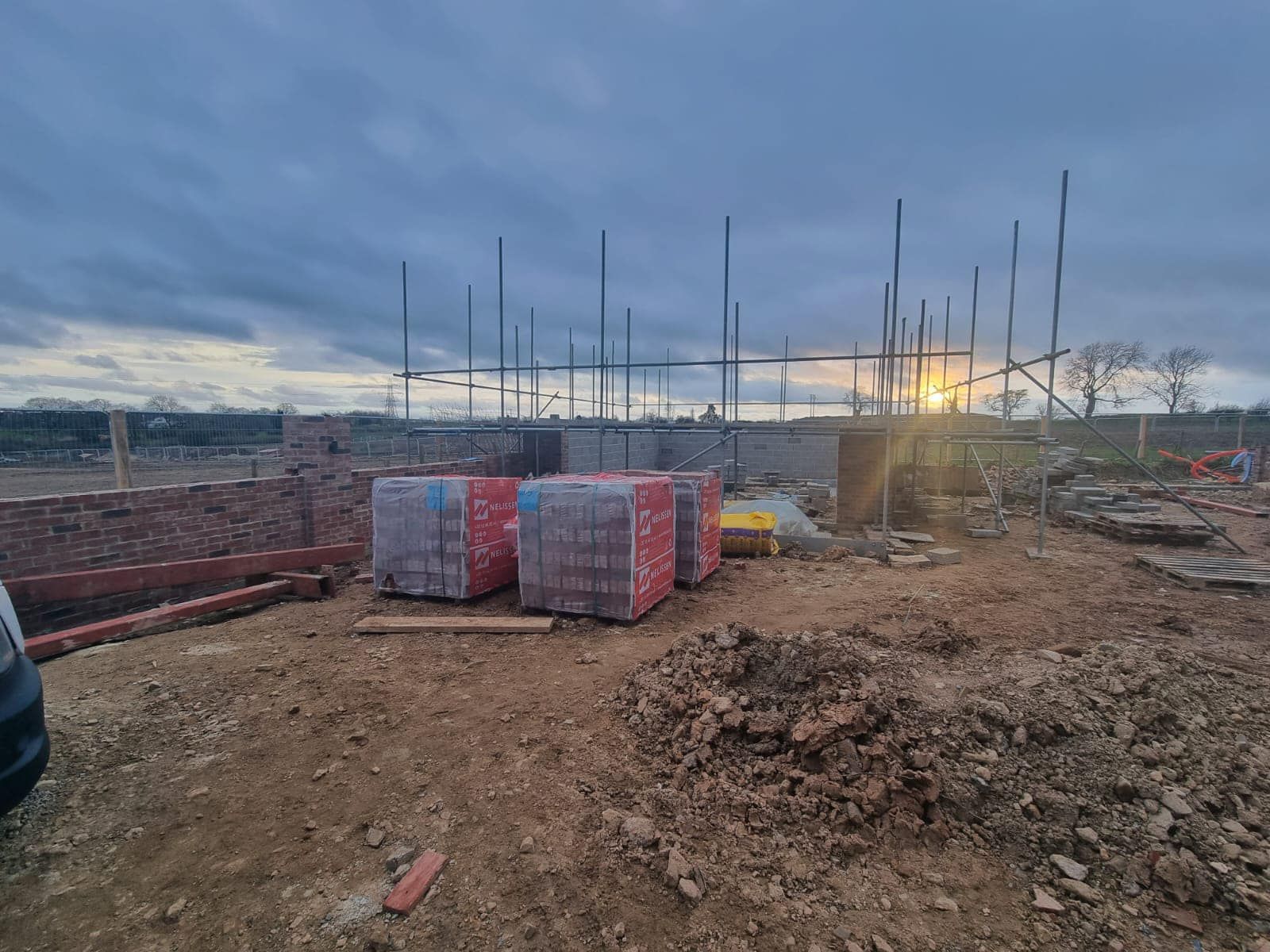 A construction site with a lot of bricks and scaffolding.