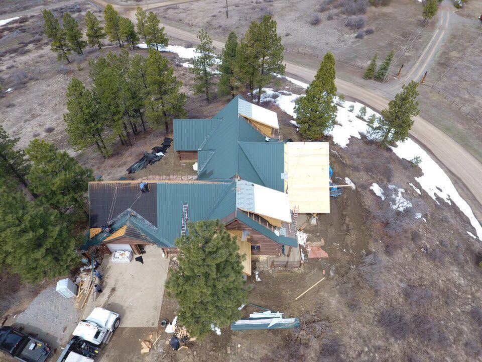 Green standing-seam metal roof installation on a rural Four Corners home