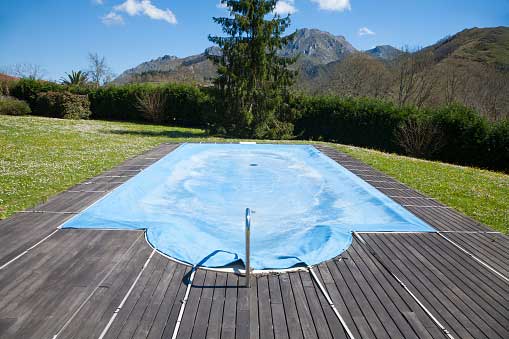 A swimming pool with cover and grass on the side | Penrith, NSW | Ian’s Pools Penrith