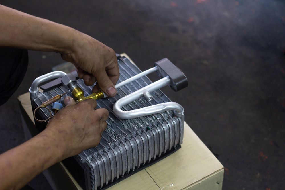 A Person Is Working On A Piece Of Metal On A Box — Airborne Auto Air in Wyong, NSW