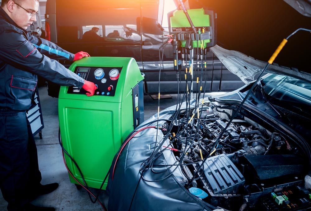 A Man Is Working On A Car With The Hood Open In A Garage — Airborne Auto Air in Gosford, NSW