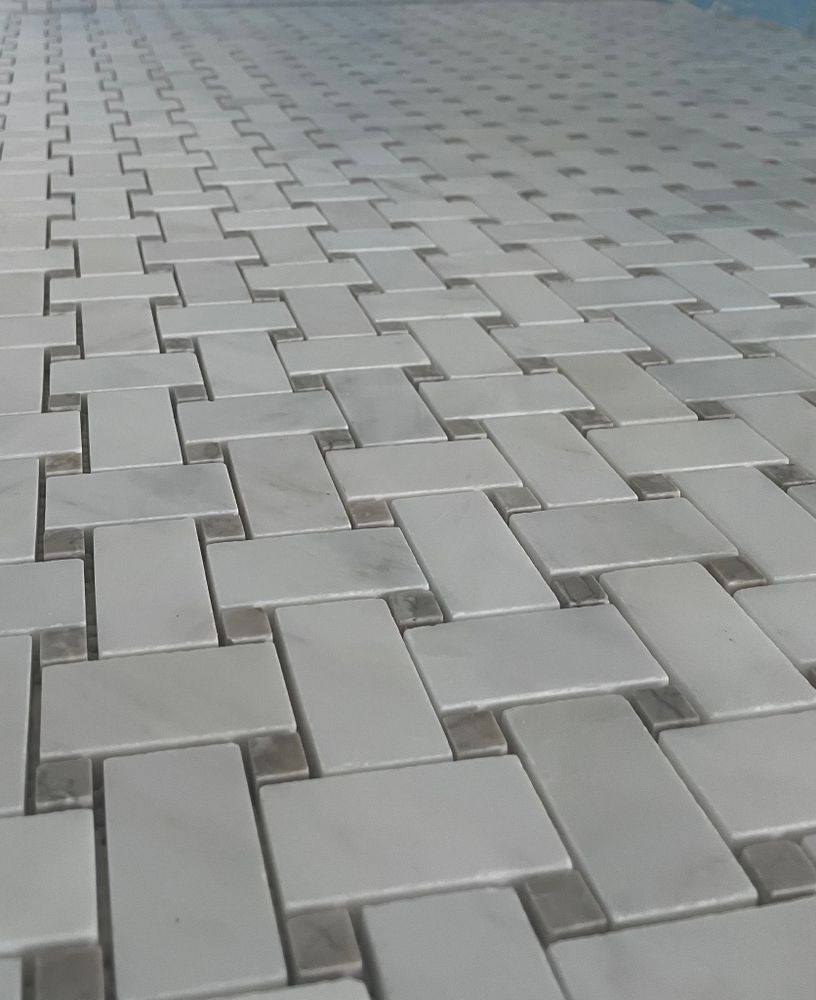 Overhead view of a gray tiled surface arranged in a basketweave pattern.