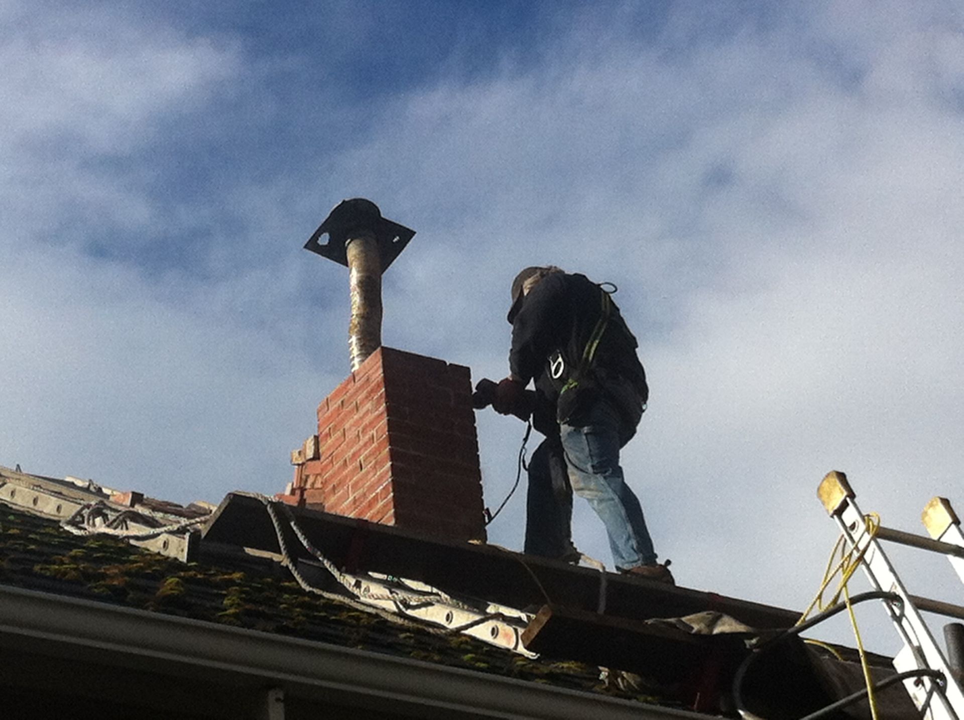 A person is cleaning a gutter with a high pressure washer.