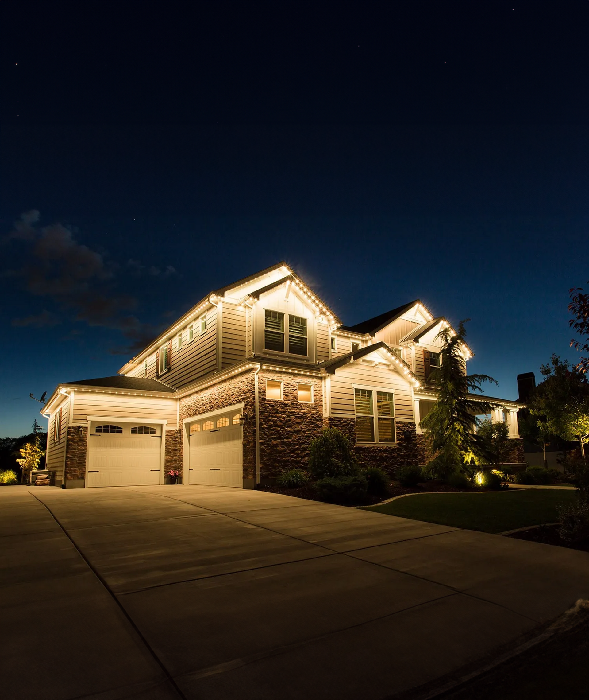 A large house is lit up at night with christmas lights.