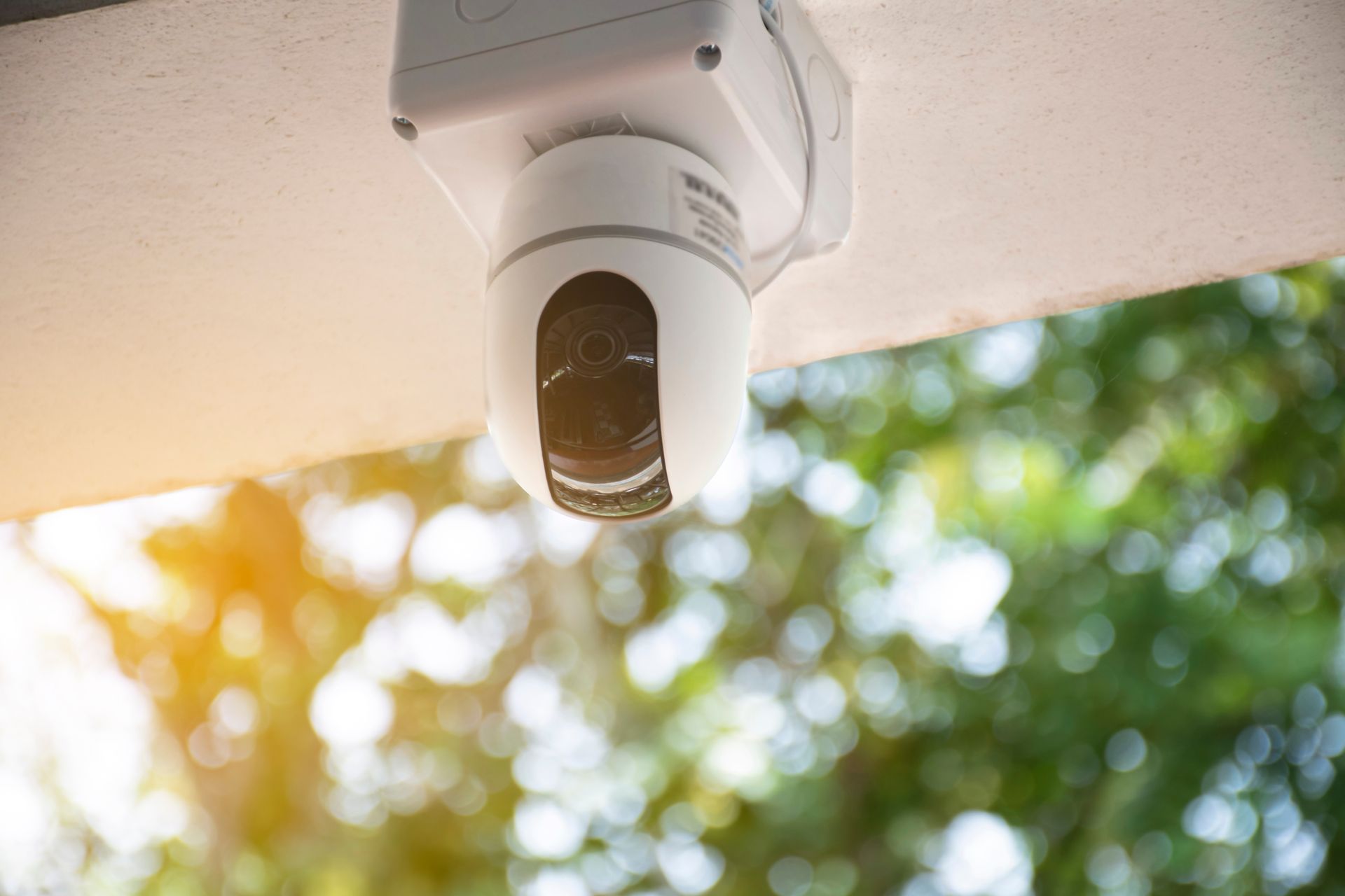 A security camera is hanging from the ceiling of a building.