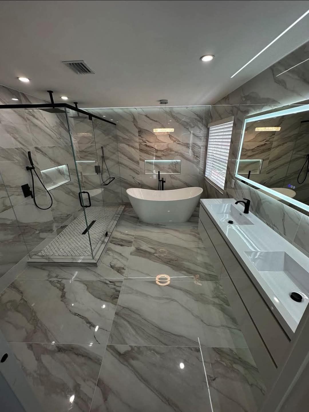 Une salle de bain avec baignoire, lavabo, douche et miroir.