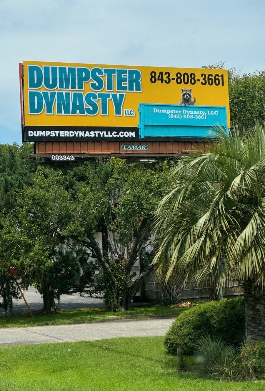 Dumpster Dynasty billboard above trees and palm fronds with blue and orange signage.