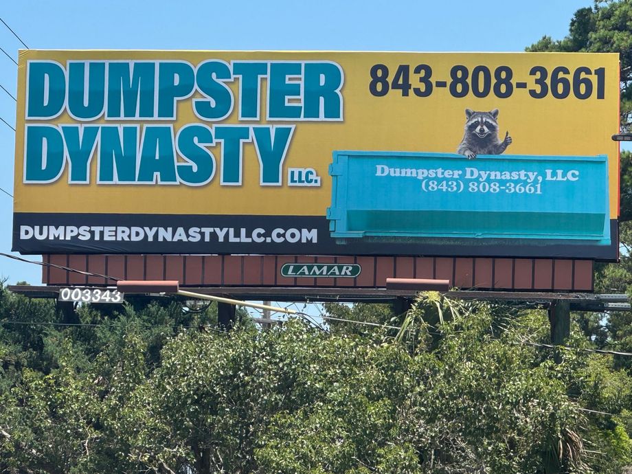 Dumpster Dynasty billboard with blue and yellow signage, phone number, and website over trees.