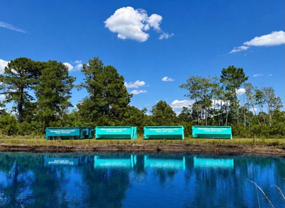 Blue lake reflecting turquoise train cars under a bright sky with trees along the shore