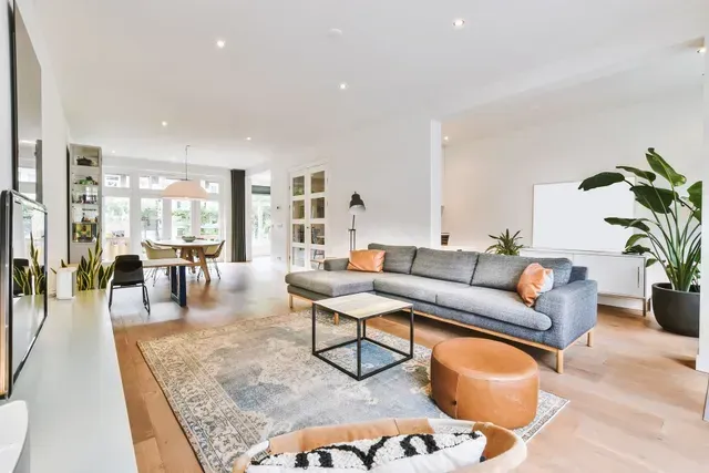 Un salon avec un canapé, une table basse et un pouf.