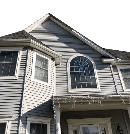 A low-angle view of the front exterior of a gray, two-story vinyl-sided home with a prominent arched window.